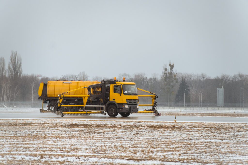 truck spraying de-icing fluids on runway